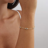 Pulseira delicada banhada a ouro com zircónias transparentes e castanhas